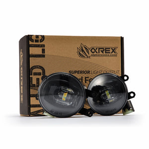 Two black AlphaRex Dual Color LED Projector Fog Lights for Toyota Tacoma on a box